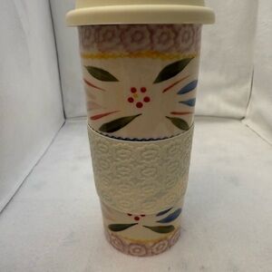Temptations ceramic travel mug with a floral pattern and silicone sleeve.